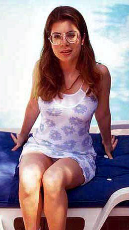 Alessia Gerini siting on a poodside bed wearing a sun dress and sneakers